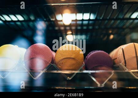 Des macarons multicolores sur une vitrine dans un café Banque D'Images