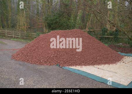 Grande pile de scalnings de pierre rouge sur le Drive of a Country Cottage Garden à Rural Devon, Angleterre, Royaume-Uni Banque D'Images