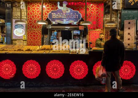 Un client achetant des bonbons du Moyen-Orient sur le marché de Mahane ou de Machane Yehuda, souvent appelé « The Shuk », un marché en plein air à Jérusalem-Ouest, en Israël Banque D'Images