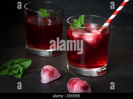 Jus de canneberge avec glaçons en forme de cœur sur fond sombre. Vue de dessus. Banque D'Images