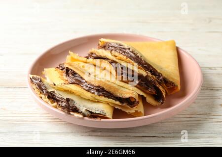 Plaque de crêpes avec pâte de chocolat sur fond de bois blanc Banque D'Images