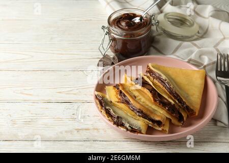 Concept de délicieux petit déjeuner avec crêpes et pâte au chocolat fond en bois blanc Banque D'Images