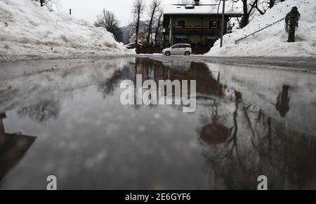 Garmisch Partenkirchen, Allemagne. 29 janvier 2021. De grandes flaques de pluie se forment dans les rues entre les montagnes de neige. Credit: Angelika Warmuth/dpa/Alamy Live News Banque D'Images