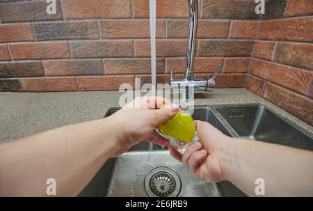 Laver le verre dans l'évier avec une éponge sur le fond moderne de la cuisine Banque D'Images