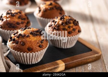 Des muffins au chocolat juste sortis du four sur une table en bois Banque D'Images