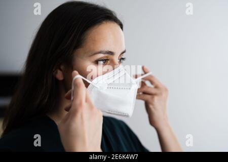 Femme mettant sur le masque médical N95 Banque D'Images