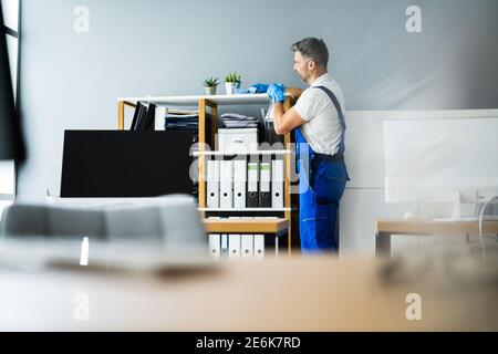 Service professionnel de nettoyage de bureau d'entretien. Homme avec un pulvérisateur de produits chimiques Banque D'Images