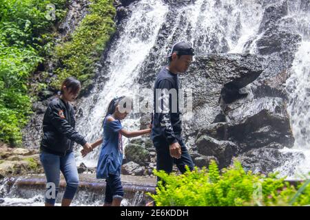 Batu City, Indonésie. Novembre 2020. La famille profite de la fraîcheur de la cascade de Watu Lumpang. Parents et enfants sont en vacances dans Fresh Banque D'Images