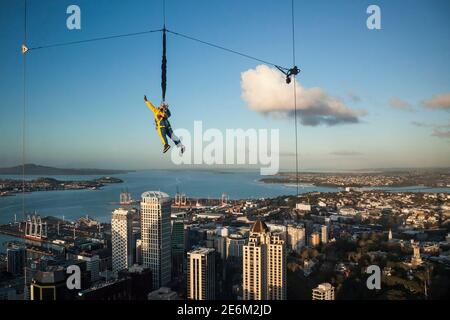 Prise de vue horizontale d'un homme qui saute au-dessus du centre-ville depuis l'observatoire Sky Tower par une journée ensoleillée, Auckland, Île du Nord, Nouvelle-Zélande Banque D'Images