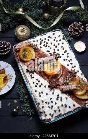 Vacances de Noël. Délicieux tiramisu orange italien avec fromage mascarpone, biscuits pour les doigts sur fond sombre. Vue de dessus. Décoration de Noël. Banque D'Images