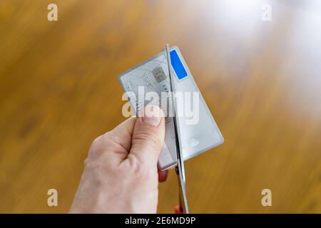 Destruction irréversible d'une carte de paiement désactivée en coupant avec ciseaux Banque D'Images