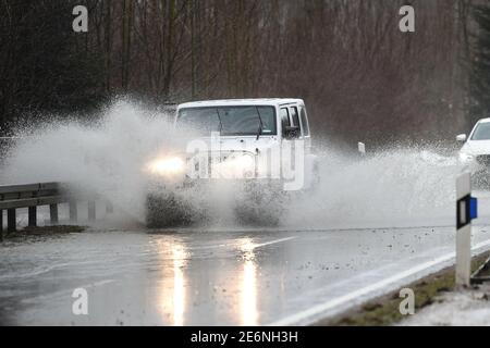 Meckenbeuren, Allemagne. 29 janvier 2021. Les voitures circulent sur une route de campagne inondée près de Meckenbeuren. Un petit flux a déjà débordé sur ses banques. Credit: Felix Kästle/dpa/Alay Live News Banque D'Images