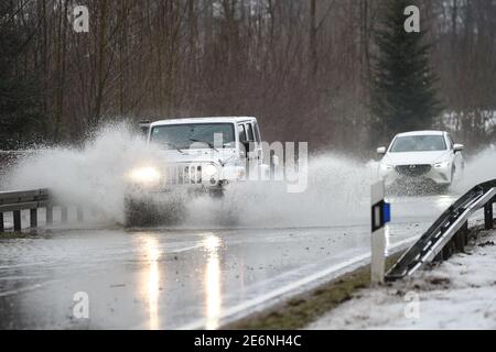 Meckenbeuren, Allemagne. 29 janvier 2021. Les voitures circulent sur une route de campagne inondée près de Meckenbeuren. Un petit flux a déjà débordé sur ses banques. Credit: Felix Kästle/dpa/Alay Live News Banque D'Images