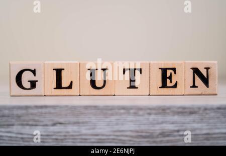 Gluten de mot sur des blocs de bois. TEXTE DE LETTRE DE GLUTEN écrit sur des blocs de bois sur une table en bois. Banque D'Images