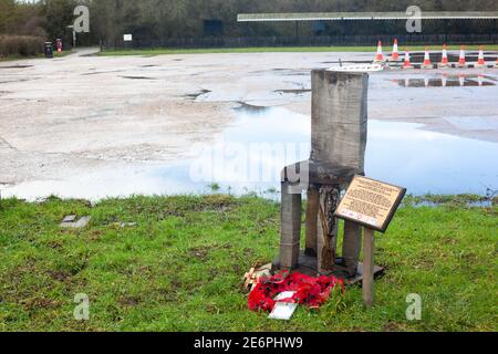 Vue sur la chaise vide, le Mémorial sculpté et les Poppies et Wreath du jour de Rememberance posés sur l'herbe, Wat Tyler Country Park, Pitsea, Basildon, Essex, Royaume-Uni Banque D'Images