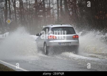 Meckenbeuren, Allemagne. 29 janvier 2021. Les voitures circulent sur une route de campagne inondée près de Meckenbeuren. Un petit flux a déjà débordé sur ses banques. Credit: Felix Kästle/dpa/Alay Live News Banque D'Images