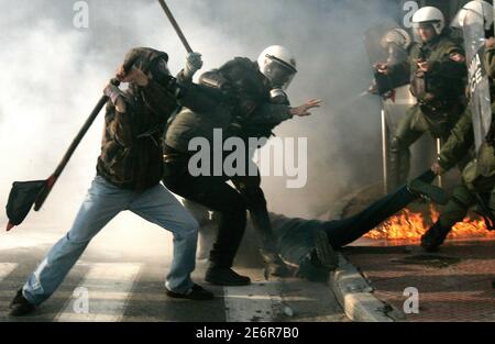 Self-styled anarchists armed with wooden sticks fight against the police in an attempt to release an arrested comrade (on the floor) in a cloud of tear gas outside the Greek Parliament in Athens February 22, 2007. Clashes erupted after protesters tried to break a police cordon as thousands of students marched through Athens to protest government plans to reform higher education and introduce private universities.  REUTERS/Yannis Behrakis (GREECE)