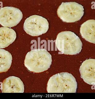 Fermez la texture de la pâte à gâteau au chocolat complet avec Cut Banane mûre prête à cuire Banque D'Images