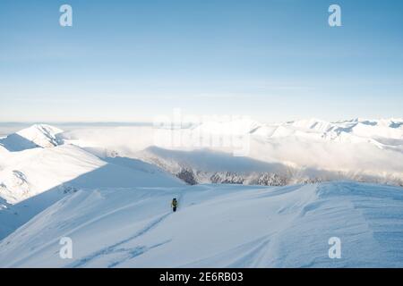 Randonneur regardant la chaîne de montagnes par beau temps. Vue depuis Mount. Couverture sur le thème de la randonnée professionnelle. Tourisme sur la crête des Tatras occidentaux. Banque D'Images