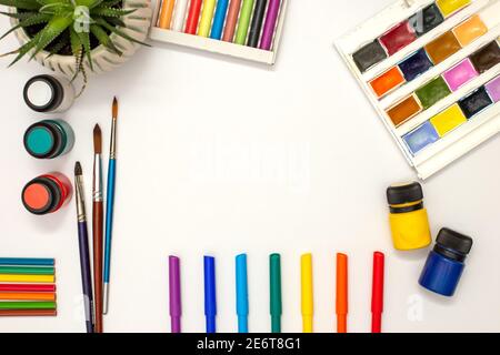 tableau blanc, fournitures de dessin : aquarelle, crayons pastel, marqueurs de couleur, pinceaux, peintures acryliques, pot succulent. Banque D'Images