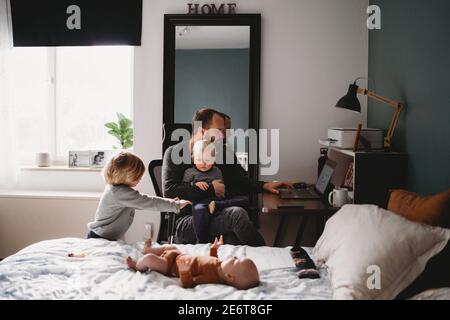 Parent essayant de travailler de la maison pendant le verrouillage avec jeune les enfants autour Banque D'Images