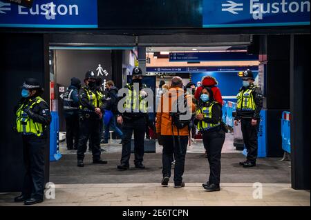 Londres, Royaume-Uni. 29 janvier 2021. La police des transports britannique effectue un contrôle ponctuel des destinations des voyageurs car Euston Station est encore assez occupé malgré le nouveau verrouillage national, rester à la maison, instructions. Ils ont déclaré qu'ils avaient condamné une personne à une amende, mais le chèque est assez doux car ils s'appuient sur l'honnêteté des passagers. La plupart des voyageurs portent des masques car ils sont déjà obligatoires. Crédit : Guy Bell/Alay Live News Banque D'Images