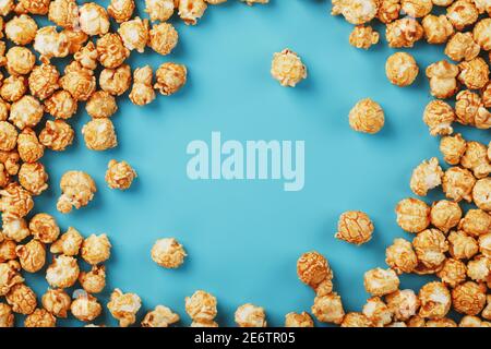 Le pop-corn est dispersé sur fond bleu, sous forme de cadre. Délicieux pour le tournage de films, séries TV, dessins animés. Espace libre, vue de dessus Banque D'Images