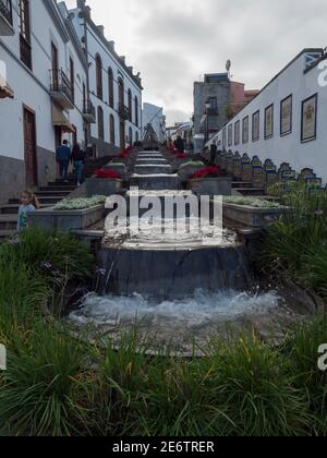 Firgas, Gran Canaria, îles Canaries, Espagne 13 décembre 2020: Vue sur la rue Paseo de Gran Canaria avec fontaine en cascade, fleurs et céramique Banque D'Images
