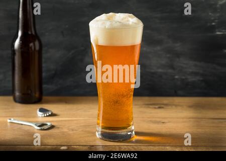 Bière dorée dans un grand verre avec mousse Banque D'Images