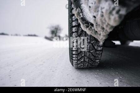 Pneus de voiture sur route d'hiver recouverte de neige. Thèmes sécurité et conduite en hiver. Banque D'Images