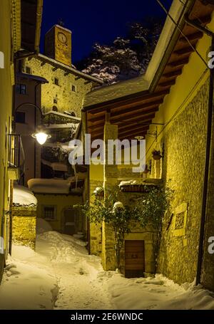 La ville de Rocca Pia après une forte chute de neige illuminée par les lumières artificielles jaunes. Banque D'Images