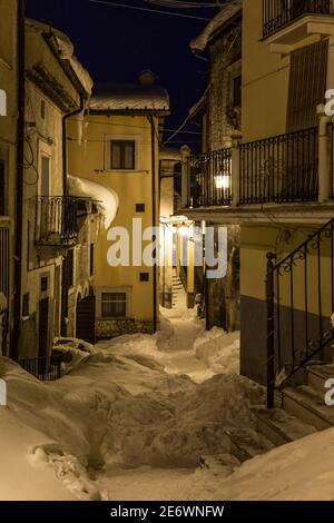 La ville de Rocca Pia après une forte chute de neige illuminée par les lumières artificielles jaunes. Banque D'Images