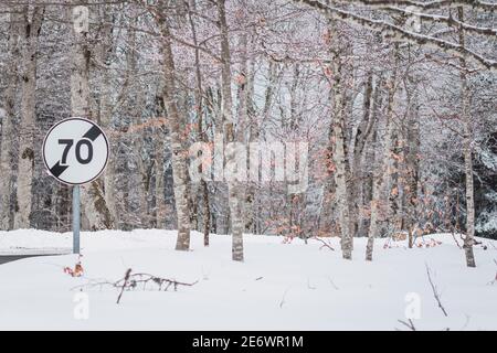Magnifique paysage d'hiver avec beaucoup d'arbres sans feuilles et un panneau de signalisation routière de limite de vitesse de 70 mph Banque D'Images