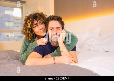 Gros plan d'un couple mignon allongé sur un lit et regarder une caméra Banque D'Images