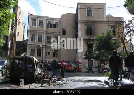 Tripoli, Liban. 29 janvier 2021. Des gens se rassemblent dans un bâtiment endommagé par des manifestants à Tripoli, dans le nord du Liban, le 29 janvier 2021. Vendredi, les hauts responsables libanais ont condamné les violentes manifestations qui ont eu lieu à Tripoli au cours des quatre derniers jours et qui ont fait des centaines de blessés en tuant un jeune homme, a rapporté l'Agence nationale de presse. Credit: Khaled/Xinhua/Alamy Live News Banque D'Images