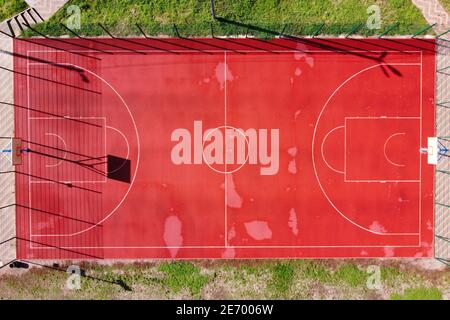 Vue de dessus du terrain de basket-ball de rue depuis drone. Vue aérienne d'un terrain de basket vide avec de l'herbe verte. Directement au-dessus de la vue. Banque D'Images