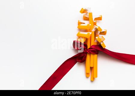 Lot de rasoirs jetables jaunes avec ruban rouge dans l'arc comme cadeau sur fond blanc, soin de la peau et toile de fond d'enlèvement des cheveux Banque D'Images