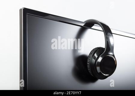 Casque de jeu sans fil noir sur un écran de PC sur fond blanc. Banque D'Images