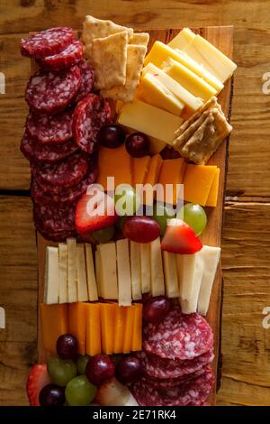 Carte de charcuterie italienne avec biscuits secs au fromage et salami planche en bois avec bord d'écorce brut Banque D'Images