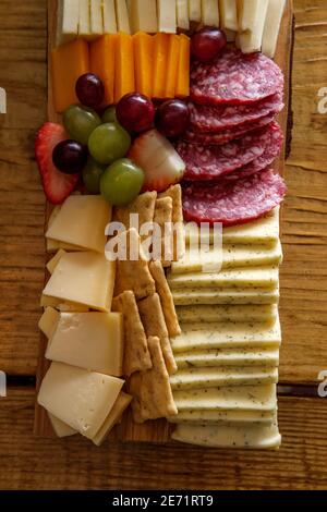 Carte de charcuterie italienne avec biscuits secs au fromage et salami planche en bois avec bord d'écorce brut Banque D'Images