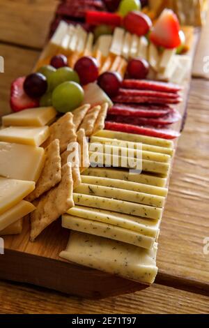 Carte de charcuterie italienne avec biscuits secs au fromage et salami planche en bois avec bord d'écorce brut Banque D'Images