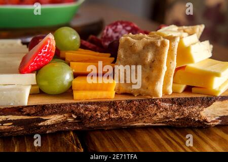 Carte de charcuterie italienne avec biscuits secs au fromage et salami planche en bois avec bord d'écorce brut Banque D'Images