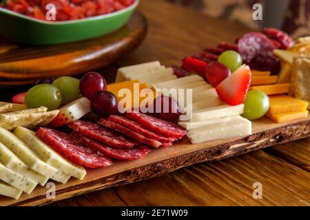 Carte de charcuterie italienne avec biscuits secs au fromage et salami planche en bois avec bord d'écorce brut Banque D'Images