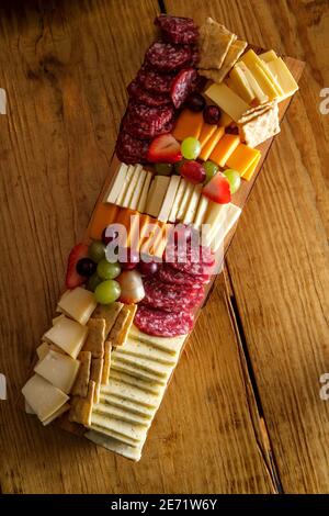 Carte de charcuterie italienne avec biscuits secs au fromage et salami planche en bois avec bord d'écorce brut Banque D'Images