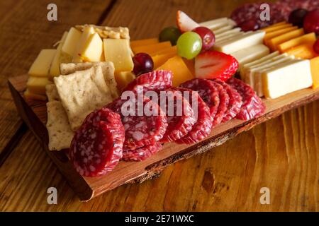Carte de charcuterie italienne avec biscuits secs au fromage et salami planche en bois avec bord d'écorce brut Banque D'Images