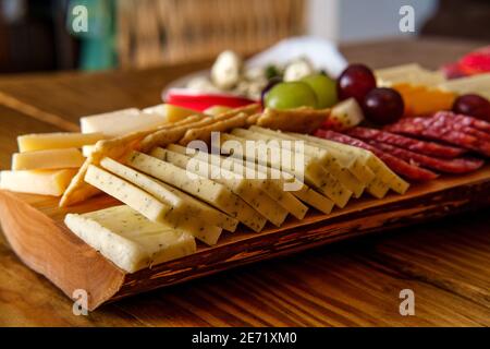 Carte de charcuterie italienne avec biscuits secs au fromage et salami planche en bois avec bord d'écorce brut Banque D'Images