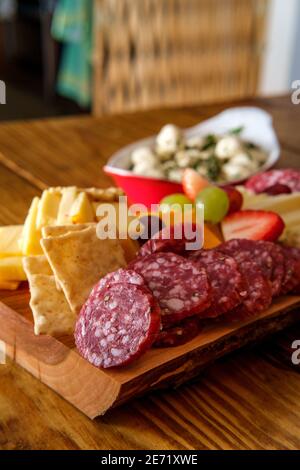 Carte de charcuterie italienne avec biscuits secs au fromage et salami planche en bois avec bord d'écorce brut Banque D'Images