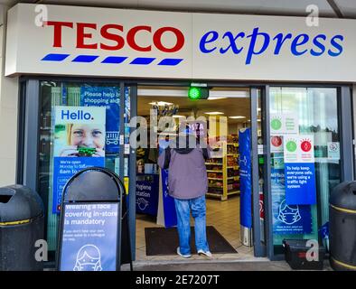 Le système d'entrée des feux de circulation d'une succursale de Tesco Express limitant le nombre de clients en magasin dans le cadre de la mesure de sécurité Covid-19. Banque D'Images
