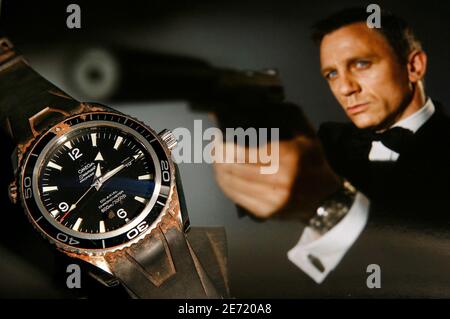 The Omega, 'Seamaster Planet Ocean' watch worn by Daniel Craig during the filming of 'Casino Royale' in 2005/2006, is pictured in front of a promotional photo during a preview at Antiquorum auction house in Geneva April 3, 2007. This watch, which is expected to reach an estimated USD $100,000 during an auction sale in Geneva April 14 and 15, will be one of the highlights with another timepiece worn by Pierce Brosnan during the filming of 'Tomorrow Never Dies' and a second one worn by Daniel Craig during 'Casino Royale'.  REUTERS/Denis Balibouse   (SWITZERLAND)