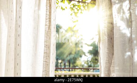 Le matin, le soleil brille sur la porte à travers les rideaux blancs. Banque D'Images